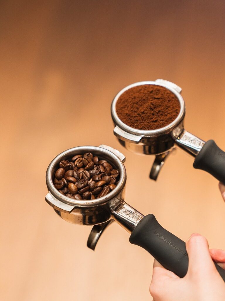 Kašika za espresso kafu sa mlevenom i przenom espresso kafom u zrnu