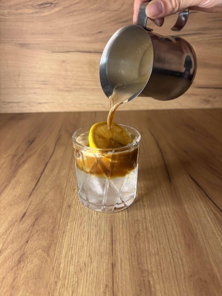 Espresso Tonic u 4 Koraka Sve Što Treba da Znate o Osvježavajućem Napitku 7 Preko kriske limuna, sipati espresso kafu u casu